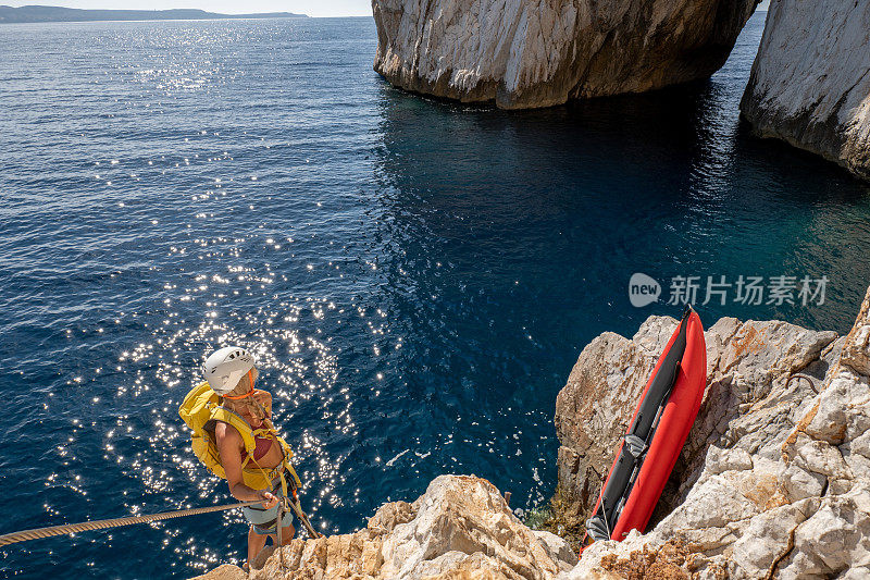 费拉塔岛(Via Ferrata)上的攀登者，年轻的妇女们在攀登海面上的岩石